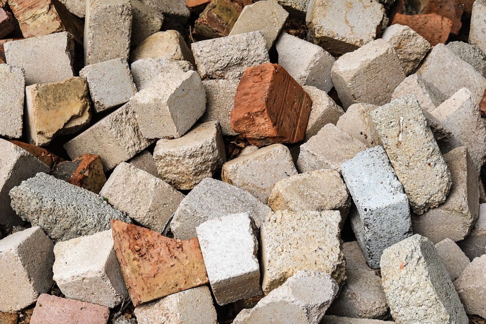 Tas de gravats : blocs de béton concassés et briques rouges issus de démolition