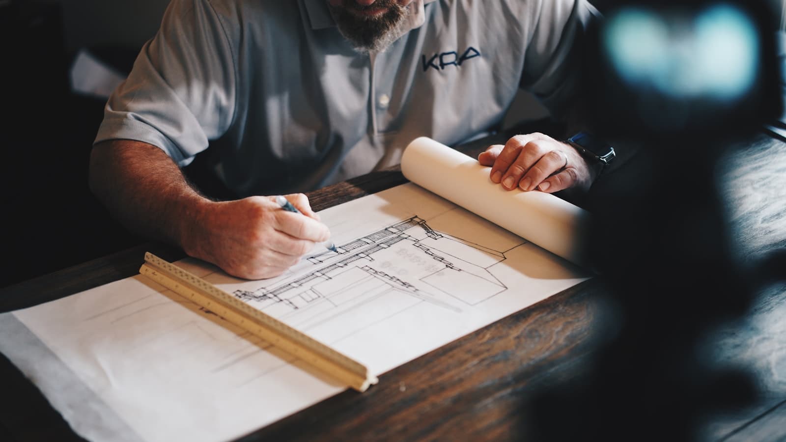 Professionnel dessinant les plans d'un projet de construction avant le dépôt du permis en ligne