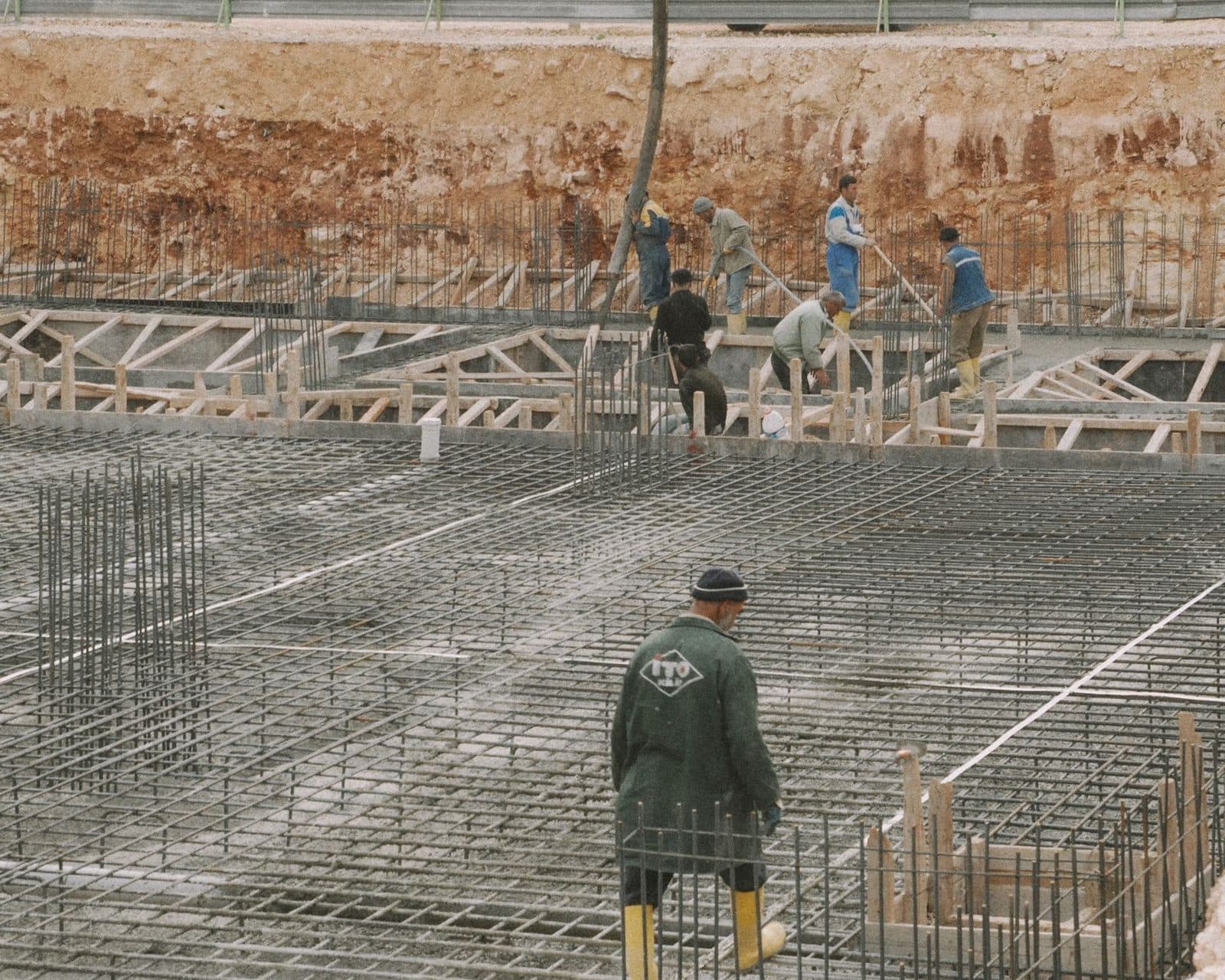 Ouvriers sur un chantier de construction posant le ferraillage d'une dalle de fondation en béton