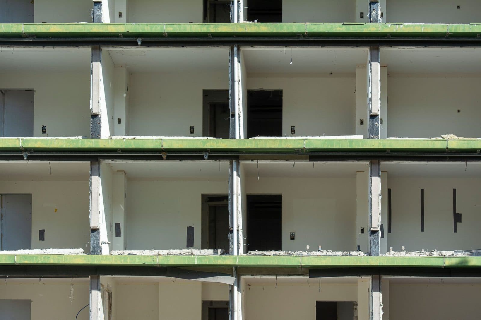 Façade d'un immeuble en chantier à l'abandon, étages ouverts sans fenêtres ni murs extérieurs
