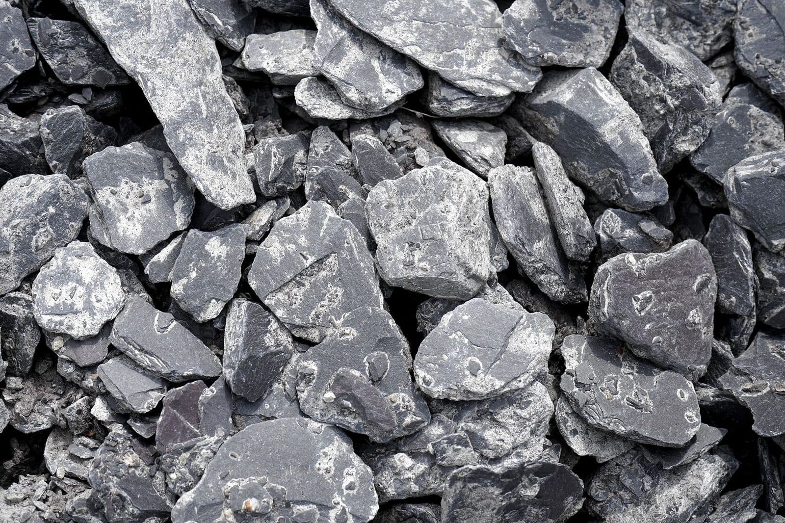 Tas de gravats de pierre concassée gris, fragments anguleux de différentes tailles vus de près