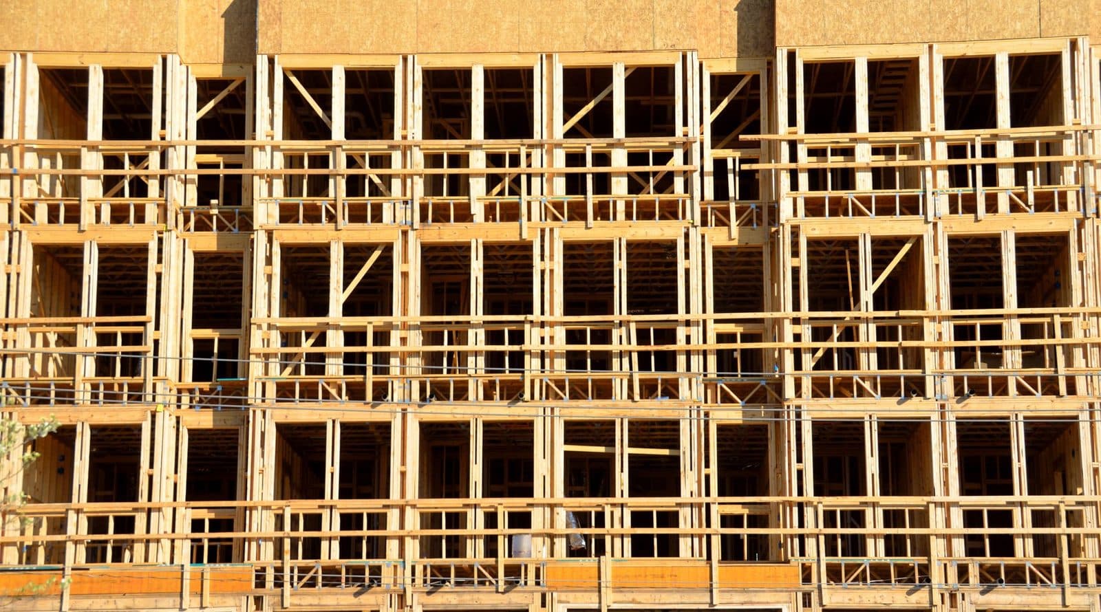 Façade d'un immeuble en construction avec ossature en bois et échafaudages