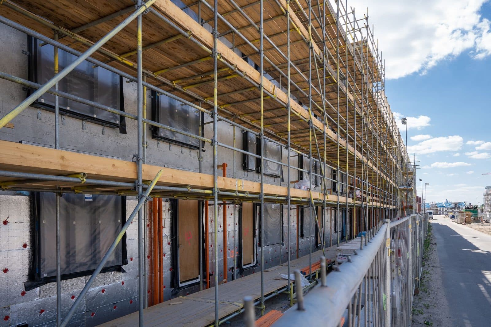 Échafaudage devant la façade d'un immeuble en chantier avec pare-vapeur et isolation extérieure